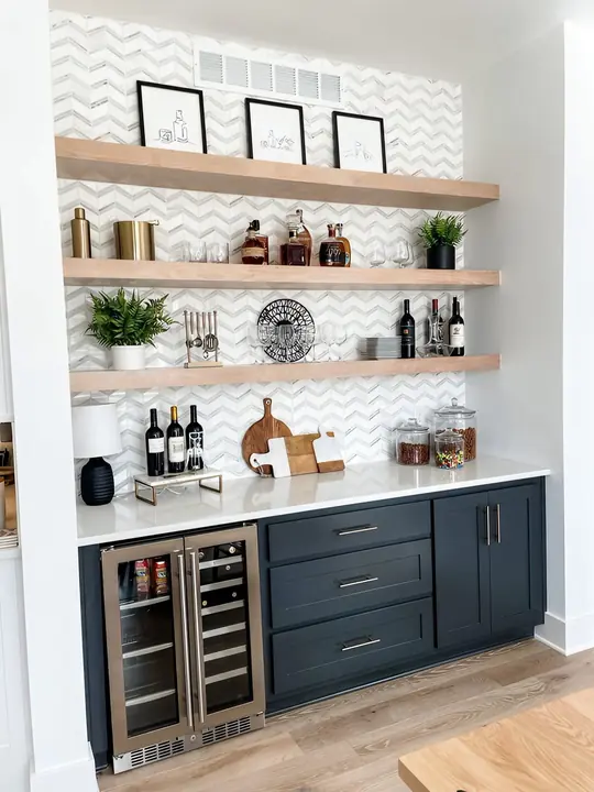 Navy bar cabinets with chevron marble tile and floating shelves