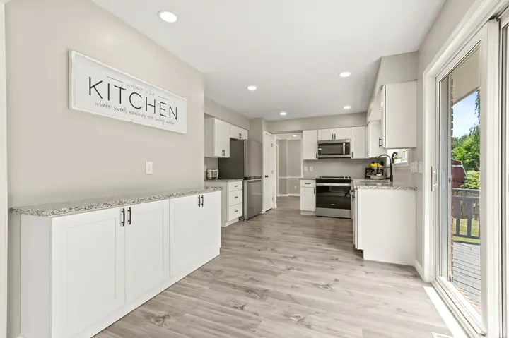 White kitchen with buffet cabinets, granite tops and LVP flooring